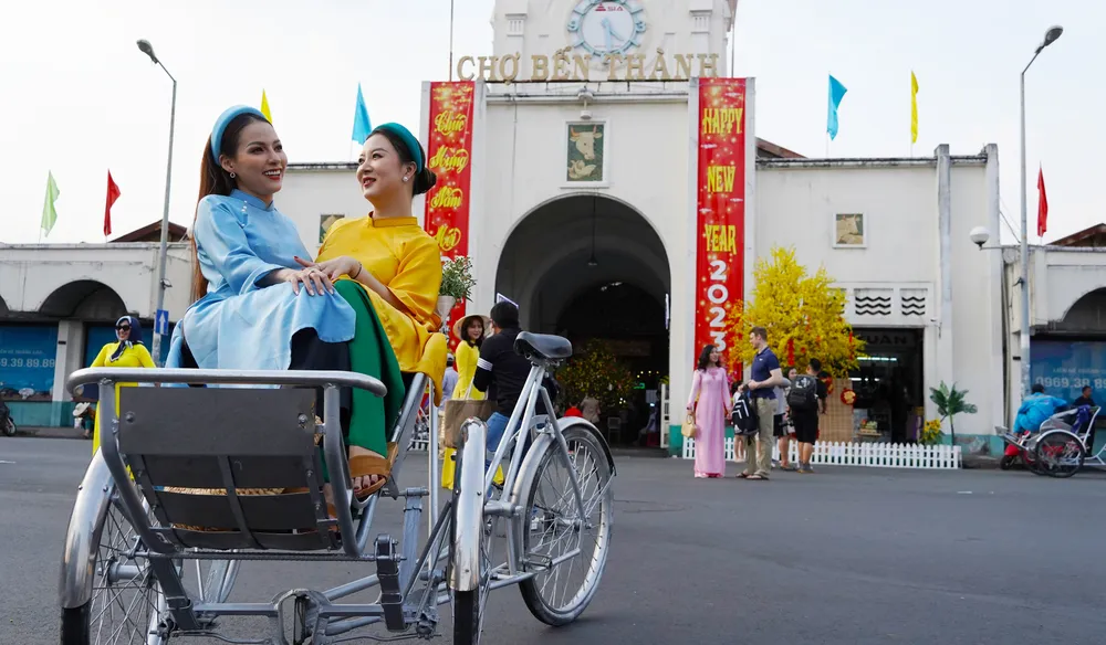 Thanh Nhã và Như Ngọc cùng nhau check-in khoảnh khắc ngày xuân trước cổng chợ Bến Thành chiều 26. Ảnh: ĐÌNH DƯ