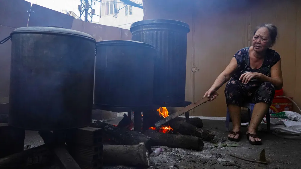 Bác Thái Thị Xinh canh nồi bánh chưng. Ảnh: ĐÌNH DƯ