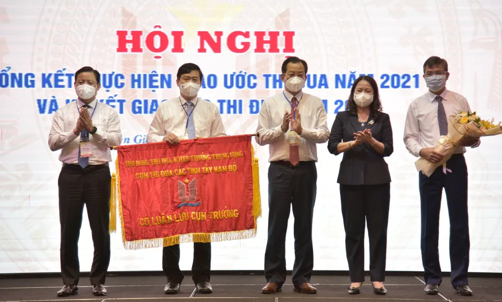 Đại diện lãnh đạo tỉnh Kiên Giang trao cờ cụm trưởng cho lãnh đạo tỉnh Đồng Tháp. Ảnh: QUỐC BÌNH