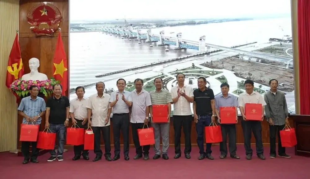 Phó Thủ tướng Trần Lưu Quang tặng quà cho bà con ngư dân. Ảnh: QUỐC BÌNH