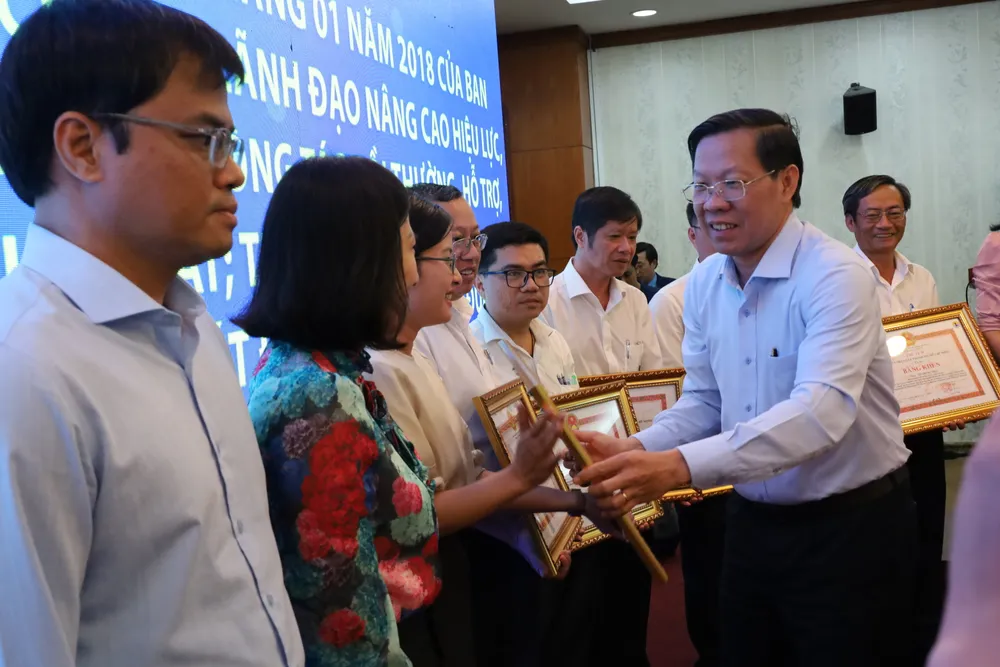 Chủ tịch UBND TPHCM Phan Văn Mãi tặng bằng khen cho các cá nhân, đơn vị hoàn thành xuất sắc nhiệm vụ. Ảnh: QUỐC HÙNG