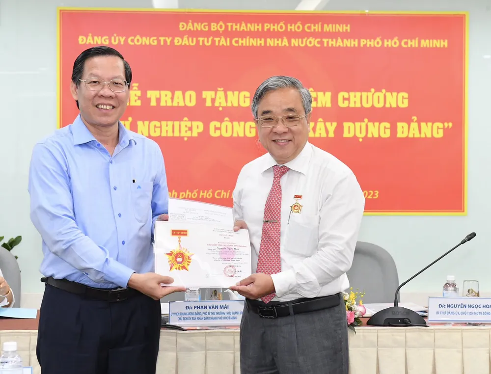 Đồng chí Phan Văn Mãi trao Kỷ niệm chương vì sự nghiệp Công tác xây dựng Đảng do Ban Tổ chức Trung ương trao tặng đồng chí Nguyễn Ngọc Hòa, Bí thư Đảng ủy, Chủ tịch HĐTV HFIC. Ảnh: VIỆT DŨNG