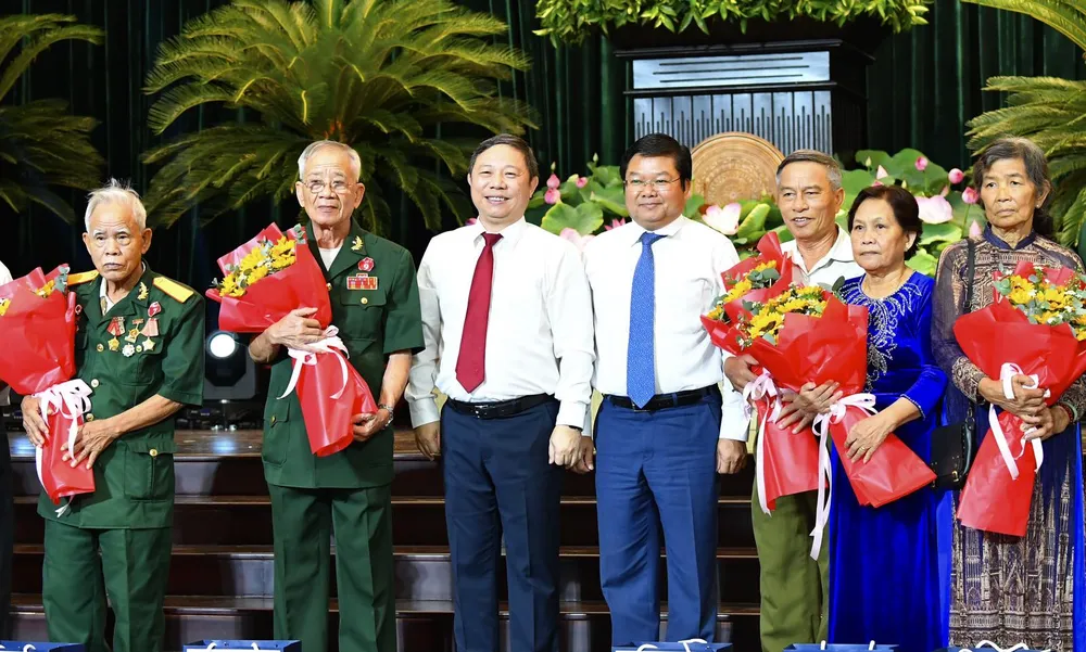 Phó Chủ tịch UBND TPHCM Dương Anh Đức và Giám đốc Sở LĐTB-XH TPHCM Lê Văn Thinh tặng hoa các đại biểu. Ảnh: VIỆT DŨNG.