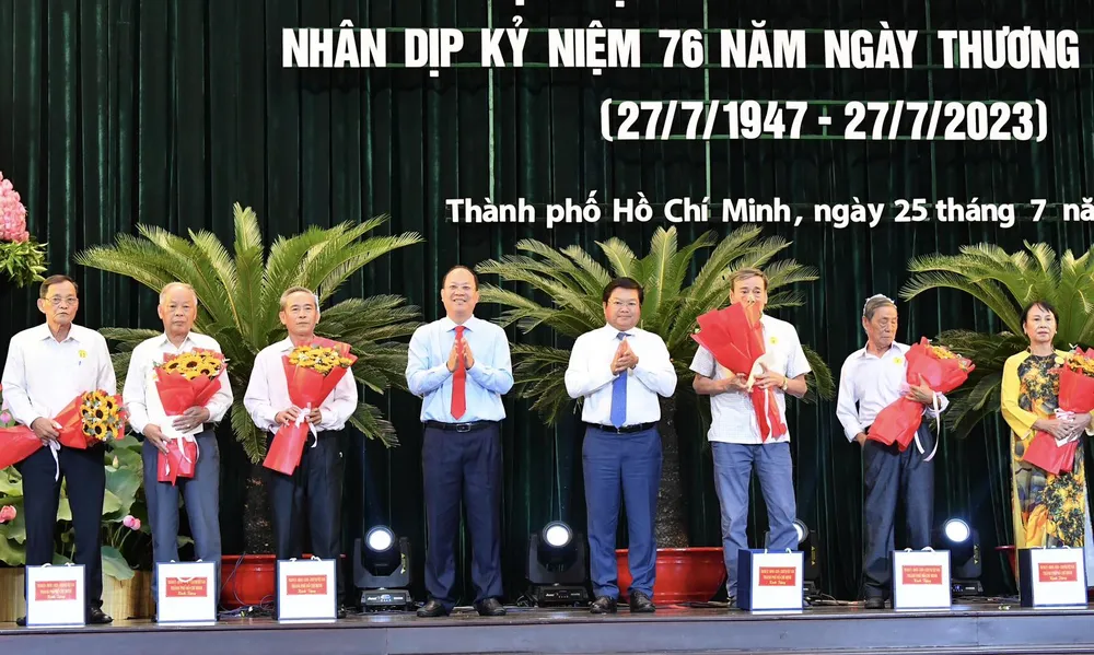 Phó Bí thư Thành ủy TPHCM Nguyễn Hồ Hải và Giám đốc Sở LĐTB-XH TPHCM Lê Văn Thinh tặng hoa cảm ơn các đại biểu. Ảnh: VIỆT DŨNG.
