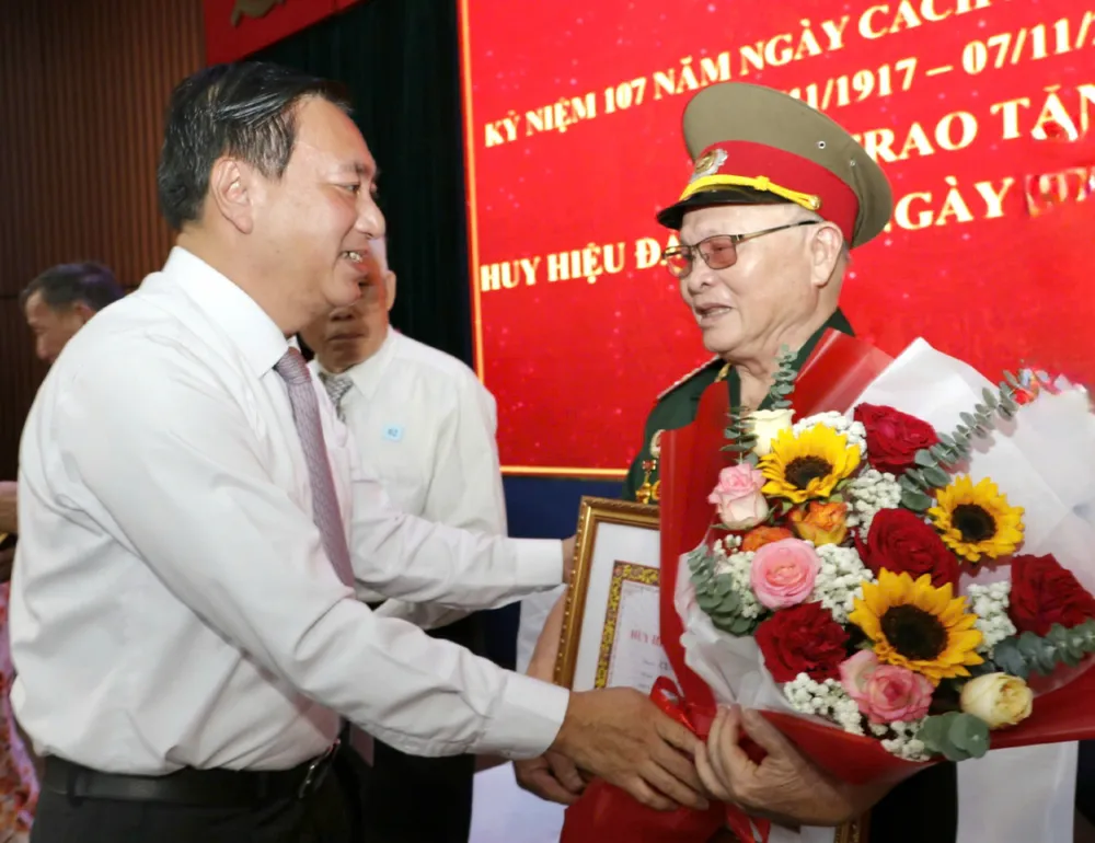 Đồng chí Phạm Thành Kiên trao Huy hiệu Đảng đến đảng viên cao tuổi đảng. Ảnh: NGÔ BÌNH