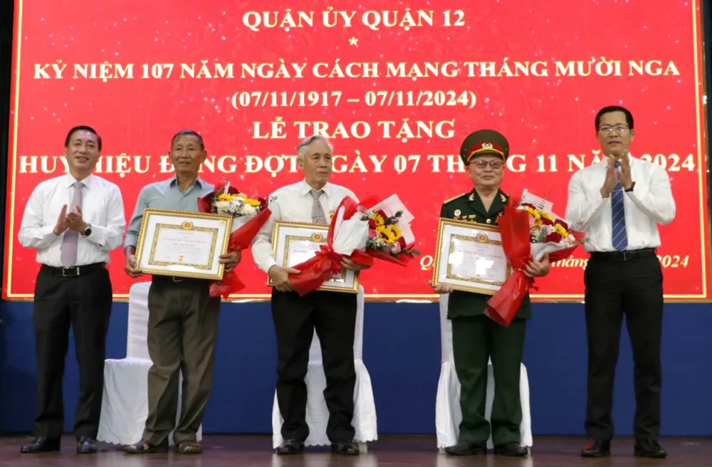 Đồng chí Phạm Thành Kiên và đồng chí Trần Hoàng Danh trao Huy hiệu 65 năm tuổi Đảng, 60 năm tuổi Đảng đến các đảng viên cao tuổi đảng. Ảnh: NGÔ BÌNH