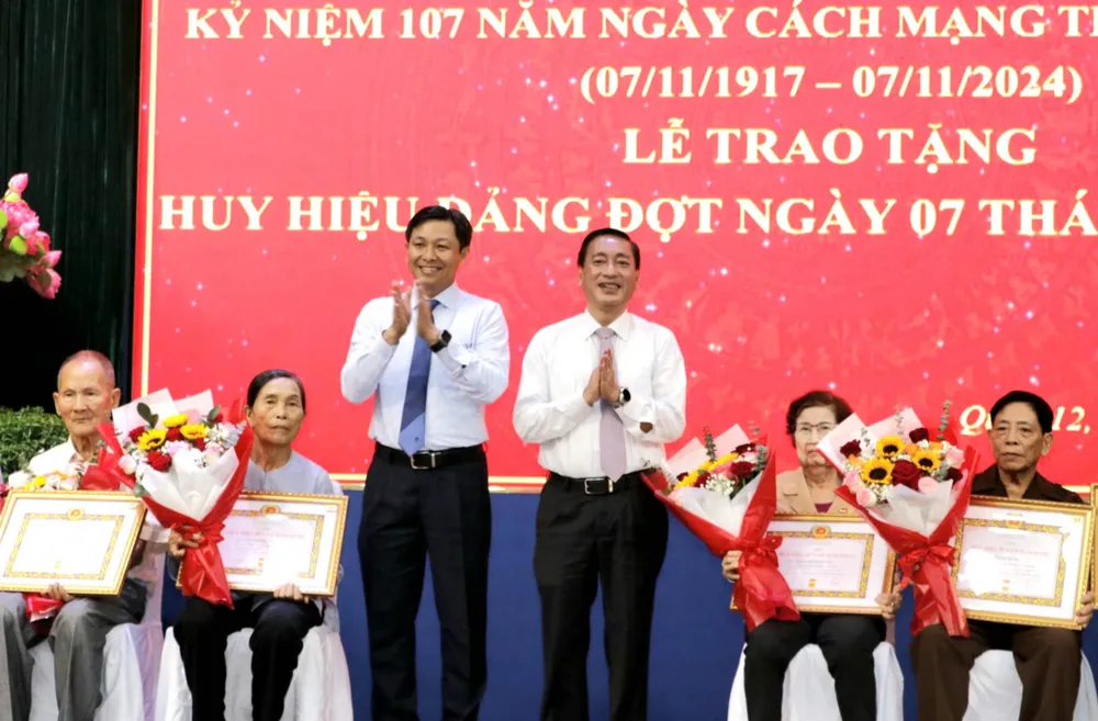 Đồng chí Phạm Thành Kiên và Chủ tịch UBND quận 12 Nguyễn Văn Đức trao Huy hiệu Đảng đến đảng viên cao tuổi đảng. Ảnh: NGÔ BÌNH