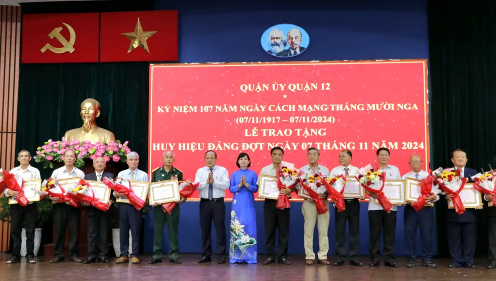 Phó Chủ tịch UBND quận 12 Nguyễn Minh Chánh và Trưởng Ban Tổ chức Quận ủy quận 12 Trịnh Thị Mỹ Lan trao Huy hiệu Đảng đến đảng viên cao tuổi đảng