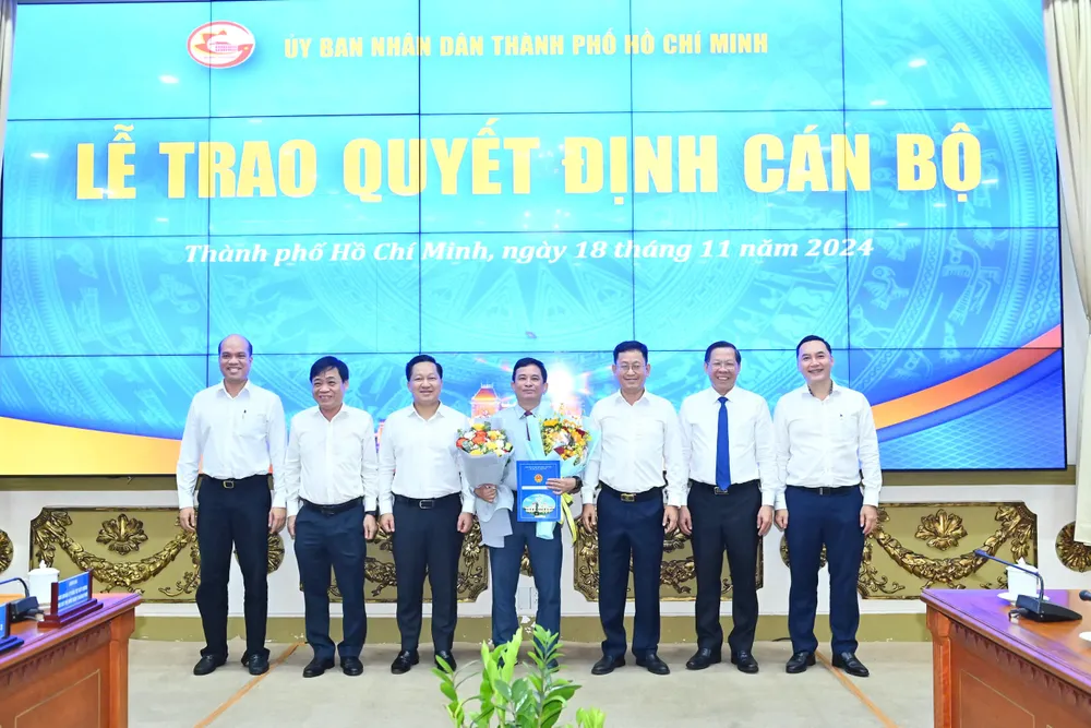 Chủ tịch UBND TPHCM Phan Văn Mãi cùng các đại biểu chúc mừng đồng chí Nguyễn Kỳ Phùng. Ảnh: VIỆT DŨNG