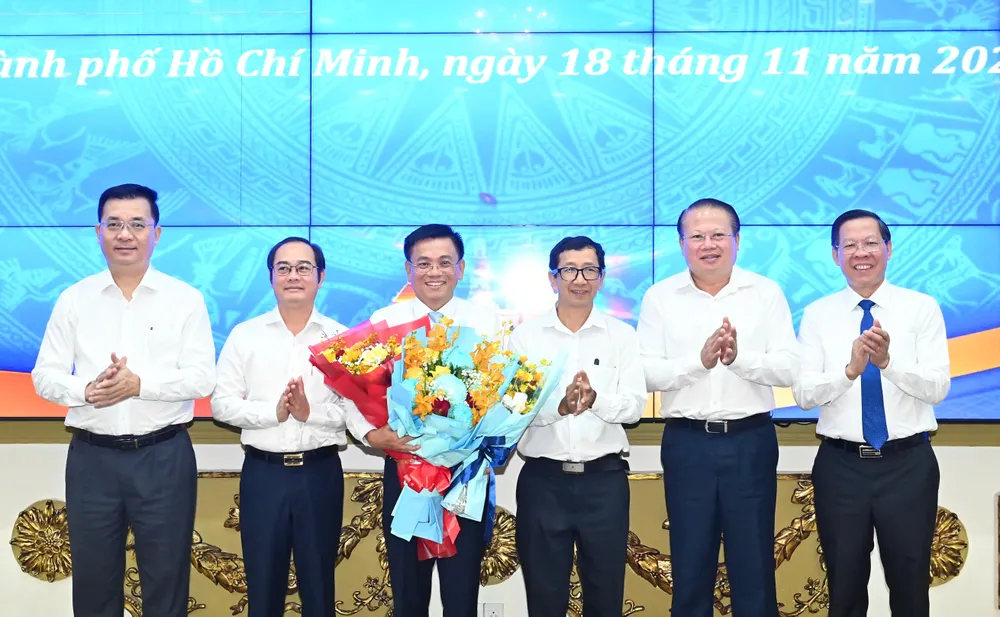 Chủ tịch UBND TPHCM Phan Văn Mãi cùng các đại biểu chúc mừng đồng chí Nguyễn Văn Tài. Ảnh: VIỆT DŨNG