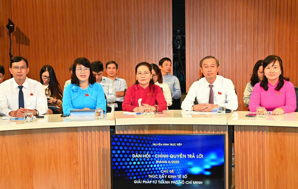 Chairwoman of the HCMC People's Council Nguyen Thi Le (red ao dai) and delegates at the program