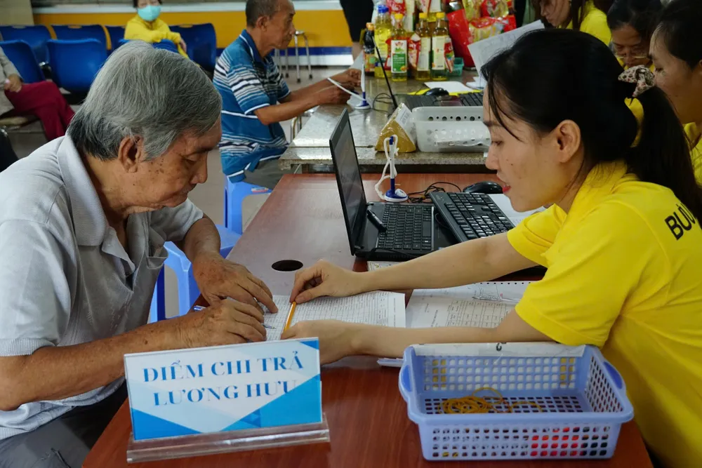 Nhân viên bưu điện chi trả lương hưu cho người hưởng.jpg