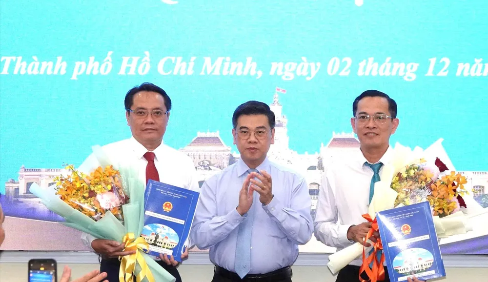 Phó Chủ tịch UBND TPHCM Nguyễn Văn Dũng trao quyết định và hoa chúc mừng ông Trương Công Huy và ông Phan Tấn Thảo