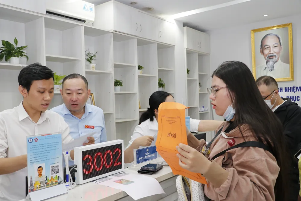 Công chức Trung tâm phục vụ hành chính công phường Bến Thành, TPHCM hướng dẫn người dân thực hiện thủ tục hành chính. Ảnh NGÔ BÌNH.JPG