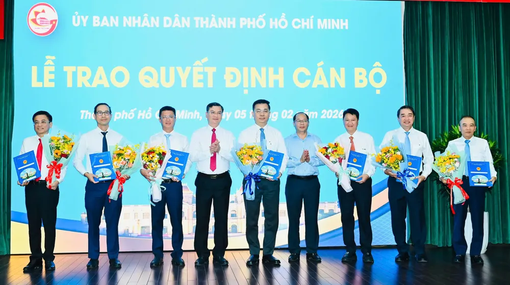 Phó Chủ tịch UBND TPHCM Nguyễn Công Vinh cùng Chánh Văn phòng UBND TPHCM Dương Hồng Thắng trao quyết định và hoa chúc mừng các cá nhân. Ảnh: VIỆT DŨNG