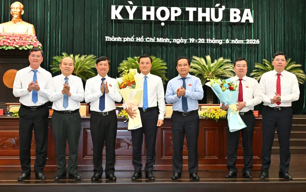 Chủ tịch UBND TPHCM Nguyễn Văn Được cùng Chủ tịch HĐND TPHCM Võ Văn Minh cùng các đại biểu tặng hoa cảm ơn đồng chí Bùi Xuân Cường và đồng chí Nguyễn Văn Đồng. Ảnh: VIỆT DŨNG
