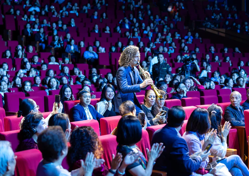 Kenny G không xuất hiện trên sân khấu mà đứng ở hàng ghế khán giả để chơi nhạc phẩm đầu tiên với giai điệu của ca khúc Home quen thuộc