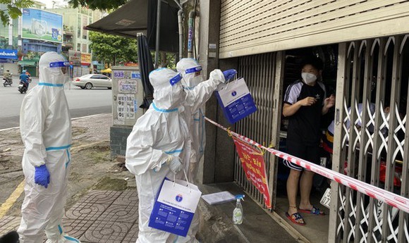 醫護人員給居家治療的確診者發藥物。