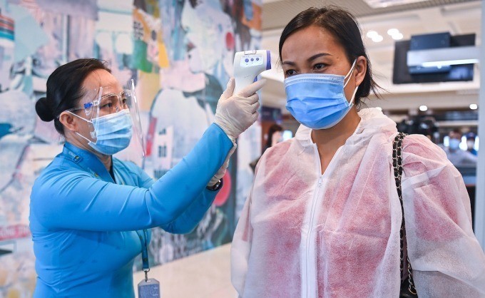 乘客在登機前測量體溫。
