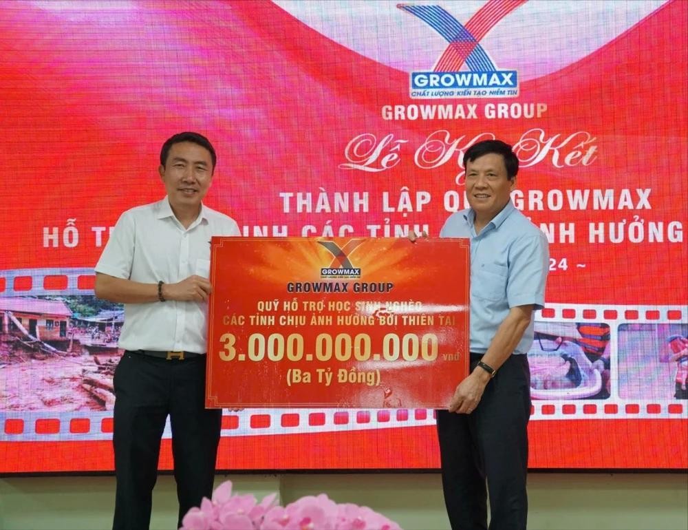 GrowMax集团总经理梅文煌向《西贡解放报》副总编辑阮玉英移交价值30亿元的象征牌。