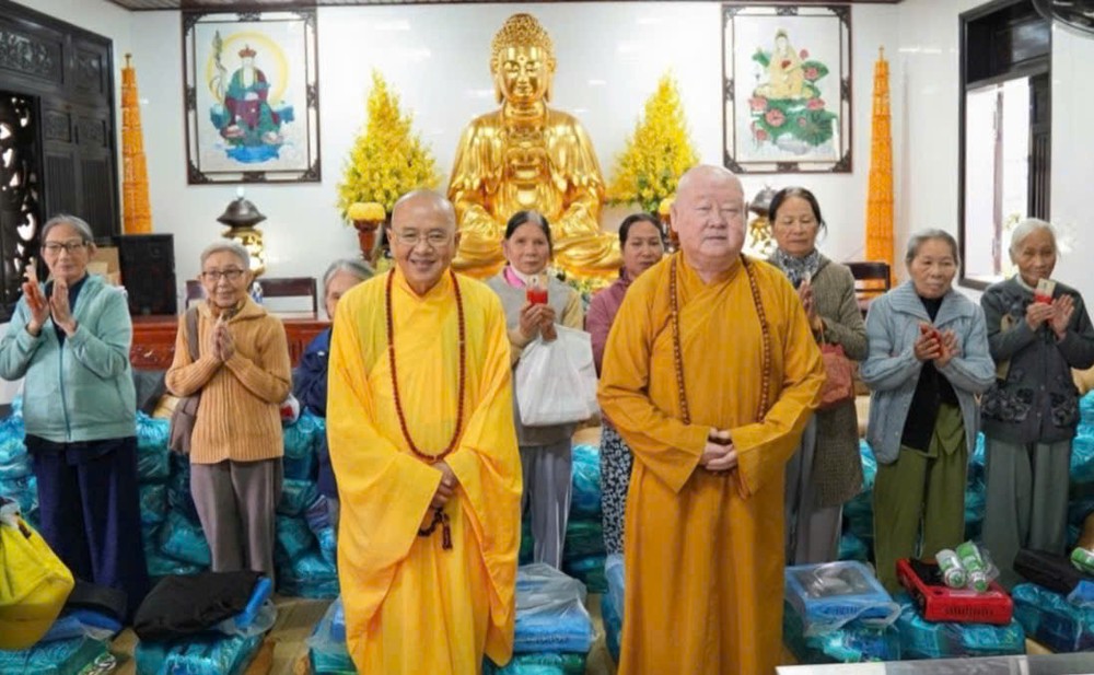 莲华寺住持释惟镇和尚（右）与顺化天明寺住持释溪真向灾民赠送礼物。