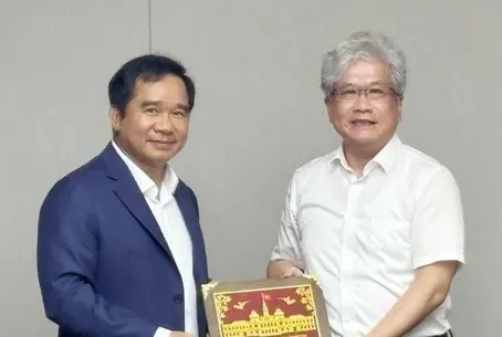 胡志明市人委会主席阮文得向临港新片区管委会领导赠送纪念品。图:陈雄、阮国