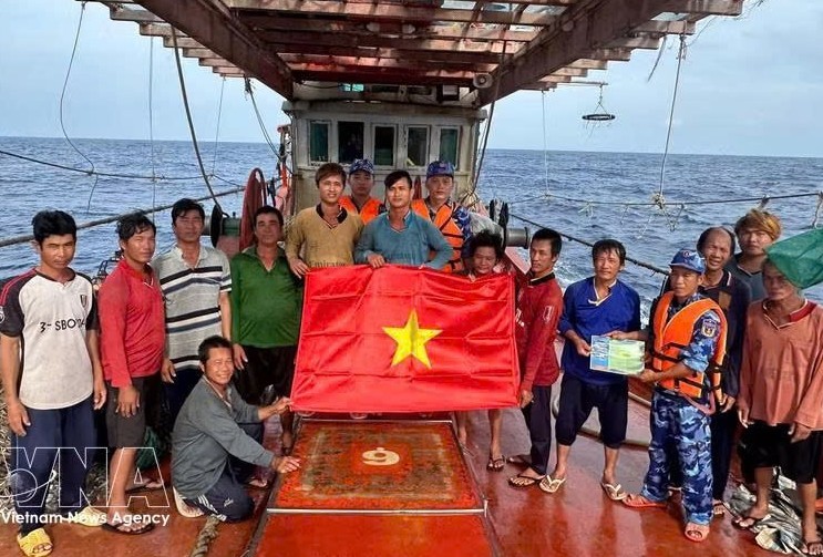 胡志明市海上执法力量向正在海上作业的渔民赠送国旗，并开展打击非法、不报告和不管制（IUU）捕捞行为的宣传活动。图片：越通社