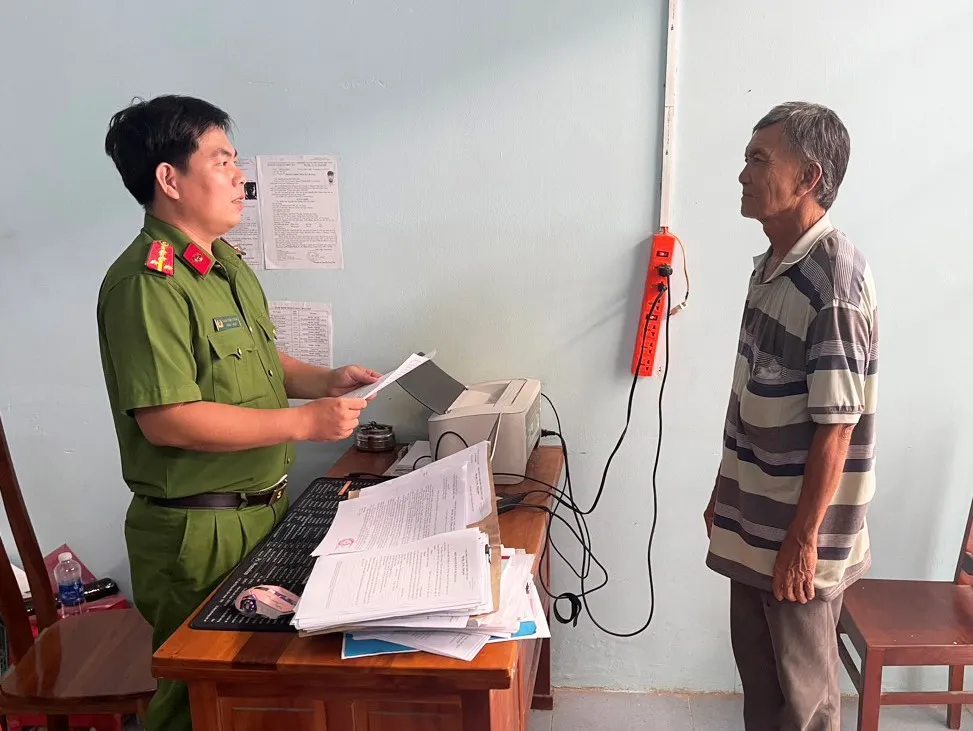 Hồ Văn Điều đang nghe cán bộ Công an tống đạt các Quyết định.jpg