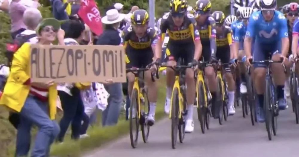 Người phụ nữ cầm bảng “Allez Opi-Omi” lấn đường đua