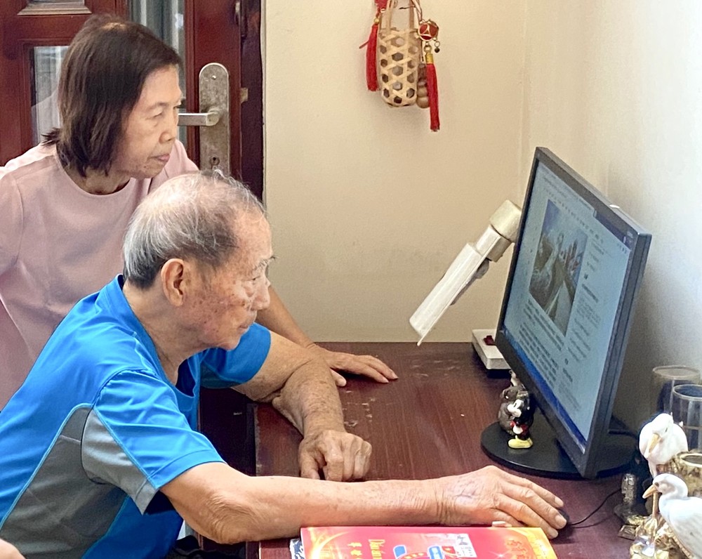 陆金和盆玉兰夫妇正在上网阅读华文《西贡解放日报》电子版。