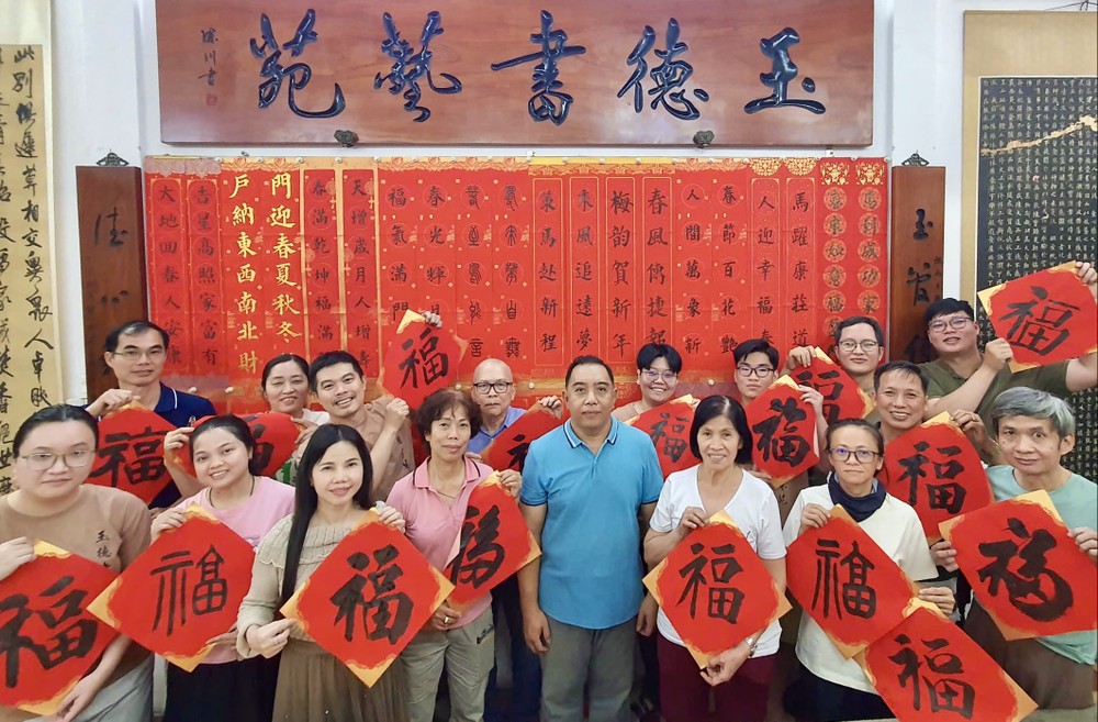 玉德书艺苑学生们持着自己挥毫的挥春，与林汉城老师合照。