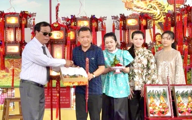 欧阳平理事长将“一帆风顺”圣灯移交给阮俊英家庭。