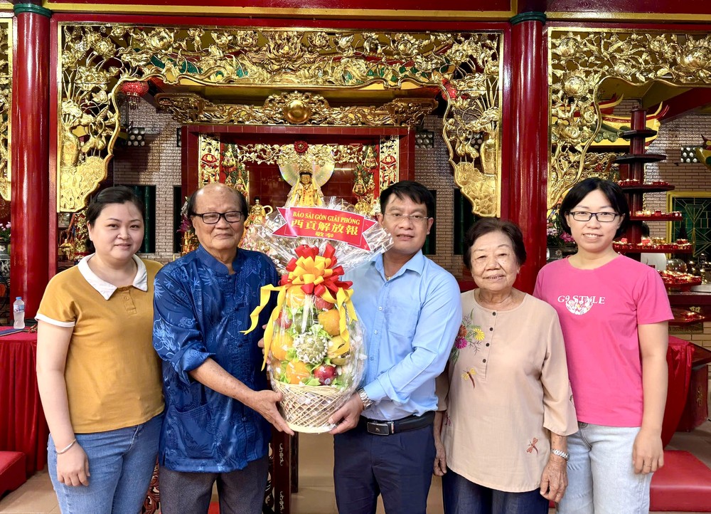 《西贡解放报》华文电子版采编部主任文忠孝向温陵会馆理事长洪世真赠送果篮祝贺观音庙成道日。