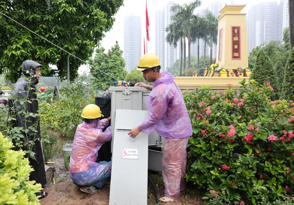 Công nhân Điện lực Hà Nội đang thi công một hạng mục công việc, sáng 23-7. Ảnh: QUANG PHÚC