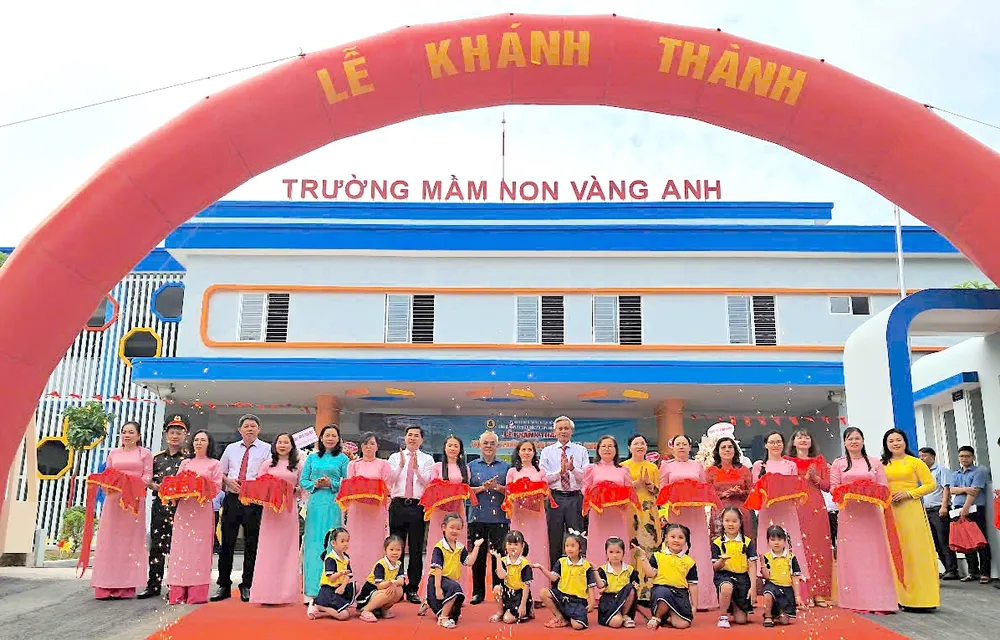 Lãnh đạo huyện Nhà Bè, chủ đầu tư, đơn vị thi công và đại diện Ban giám hiệu cơ sở 2 Trường Mầm non Vàng Anh cắt băng khánh thành ngôi trường mới. Ảnh: QUANG HUY