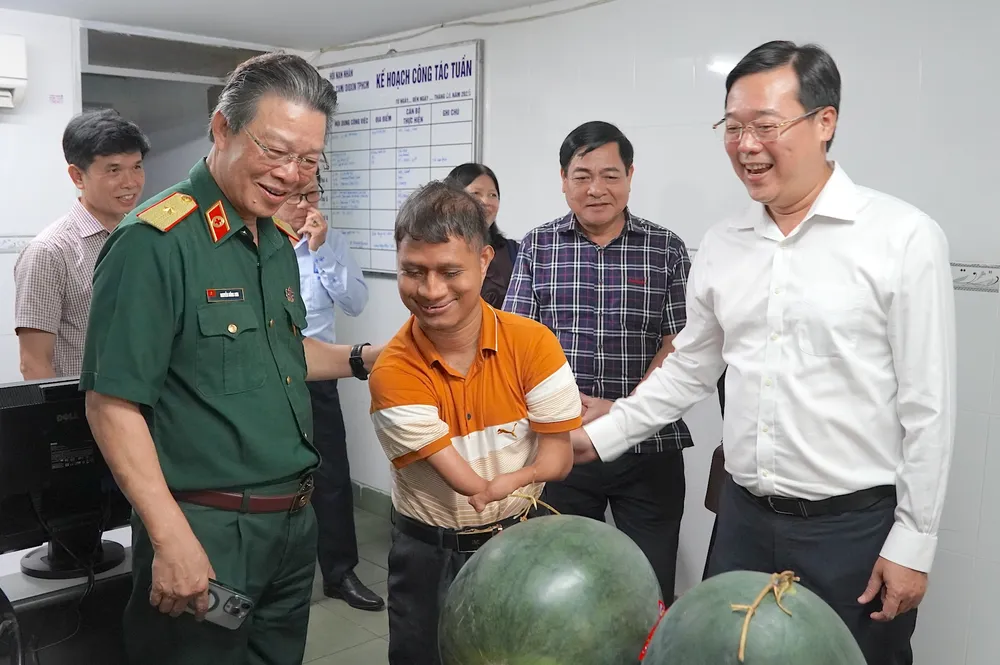 Đồng chí Lê Quốc Phong (ngoài cùng bên phải) cùng PGS-TS-BS Nguyễn Hồng Sơn thăm hỏi bạn trẻ tại Hội nạn nhân chất độc da cam/dioxin TPHCM. Ảnh: QUANG HUY