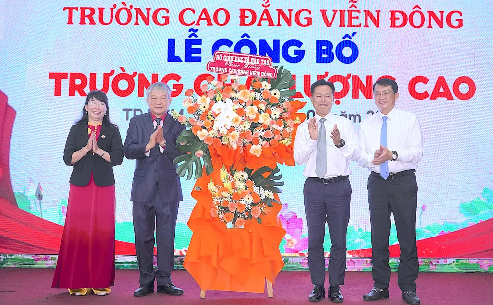 GS.TS Lê Quân, Thứ trưởng Bộ GD-ĐT (thứ 2 từ phải vào) tặng hoa chúc mừng nhà trường. ẢNH QUANG HUY