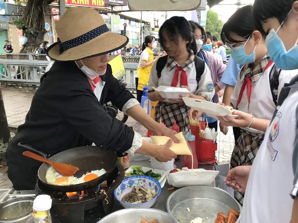 Xe đẩy bán hàng rong ở trước cổng Trường THCS Huỳnh Tấn Phát, quận 7, TPHCM. Ảnh: KIM HUYỀN