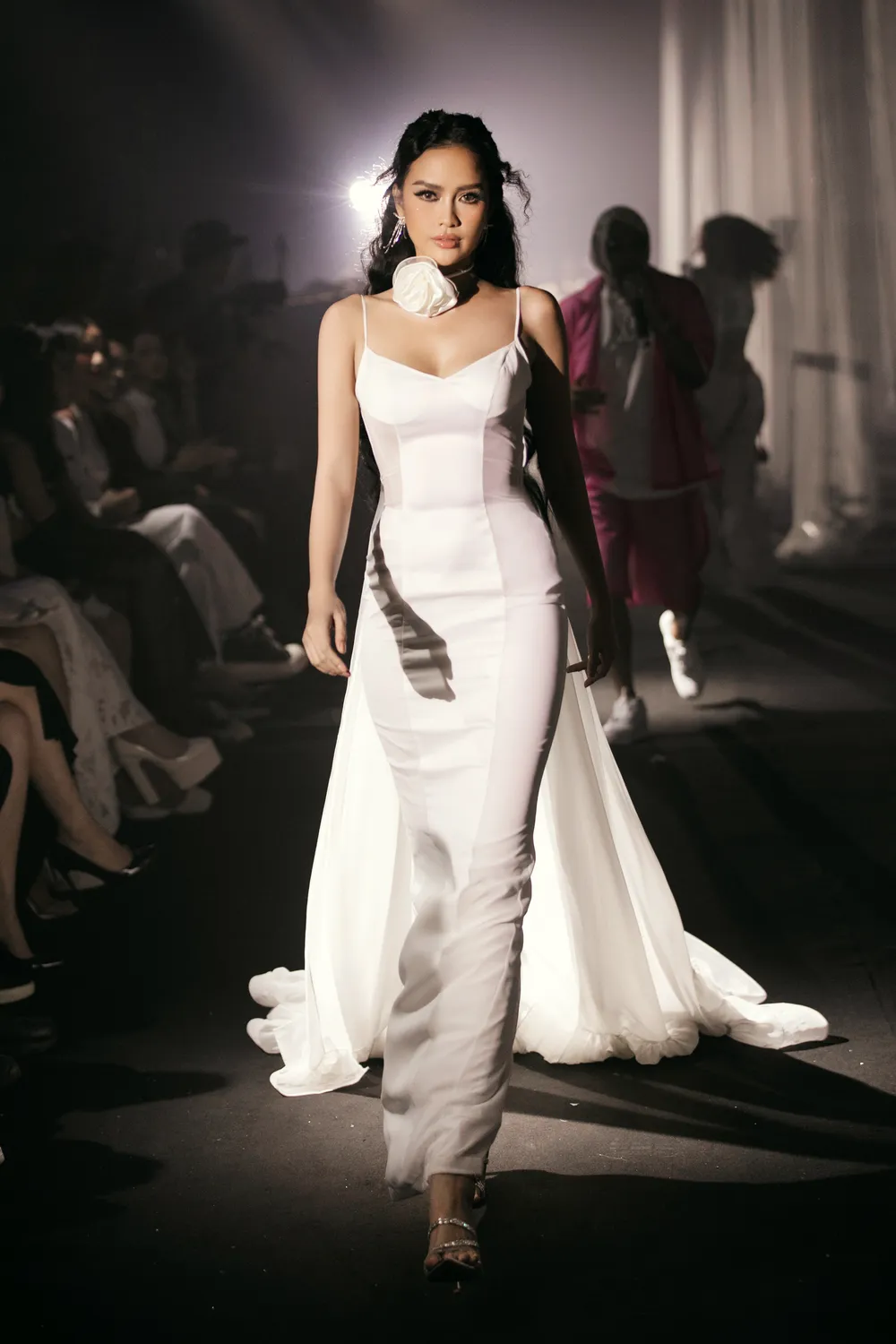 Hoa hậu Ngọc Châu trong chiếc đầm trắng tinh tế với điểm nhấn là chiếc tà dài kết hợp cùng hoa bản to cột tinh tế ở cổ, cô truyền tải tinh thần uy quyền nhưng cũng thật nữ tính