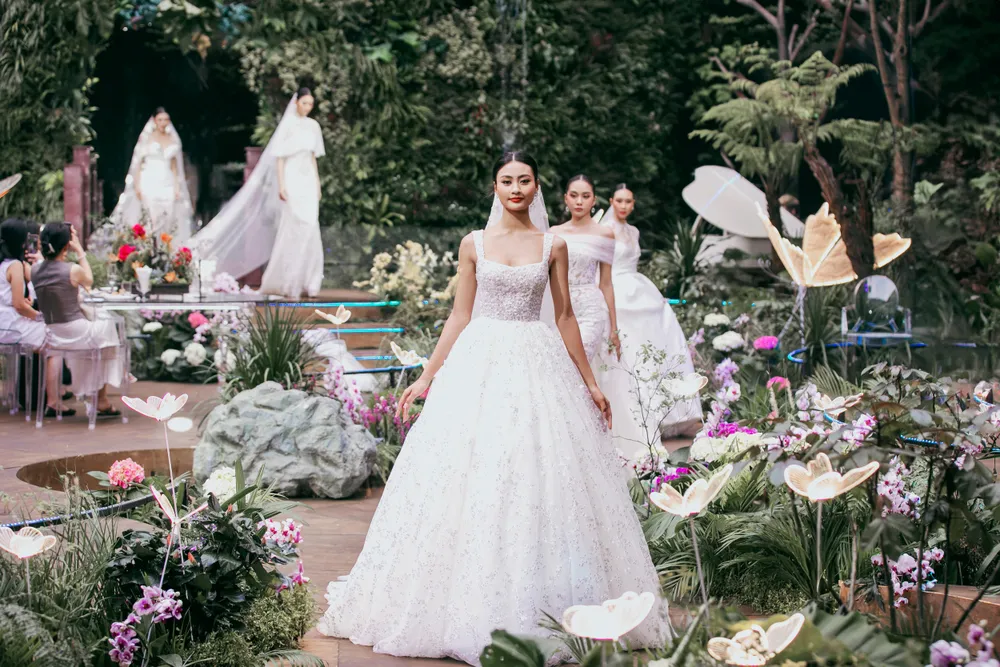 Toàn bộ phần sàn diễn được phủ màu xanh tươi mát, điểm xuyết sắc màu của các loại hoa tươi ngoại nhập và những cánh bướm xinh đẹp