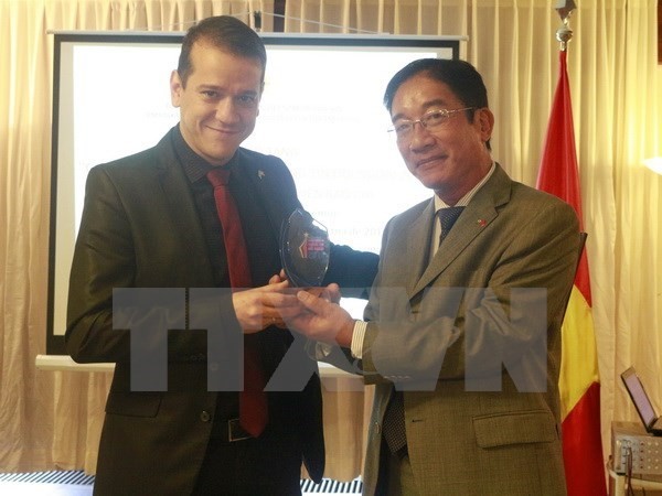 Vietnamese Ambassador to Brazil presents the National External Information Service Awards 2016 to William Gsiant, a presenter of TV Supren (Photo: VNA) 