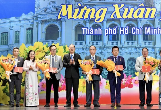 Vice Secretary of the Party Committee of the city Nguyen Ho Hai (4th,L) and Chairwoman of the municipal People’s Council Nguyen Thi Le (2nd, L) present HCMC badges to outstanding collectives and individuals. (Photo: SGGP)
