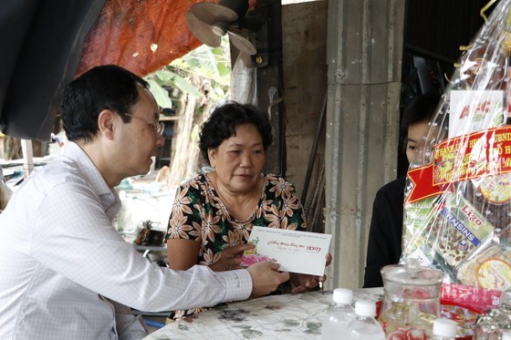 Vice Secretary of the HCMC Party Committee Nguyen Van Hieu presents Tet gifts to poor households. (Photo: SGGP)