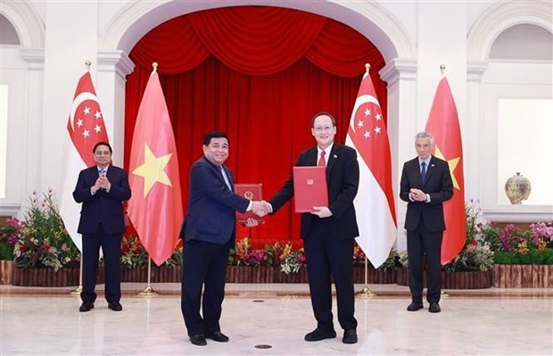 The two Prime Ministers witness the signing and hand-over of the MoU on the establishment of the Vietnam - Singapore partnership on digital economy and green economy. (Photo: VNA)