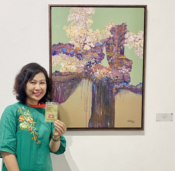 Painter Viet Kim Quyen presents her work at the display. (Photo: SGGP)