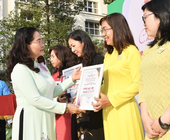 Chairwoman of the HCMC People’s Council Nguyen Thi Le presents certificates of merit to outstanding women. (Photo: SGGP)