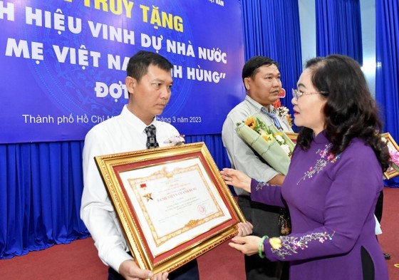 Chairwoman of the HCMC People’s Council Nguyen Thi Le offers Vietnamese Heroic Mother title to the mothers' relatives. (Photo: SGGP)