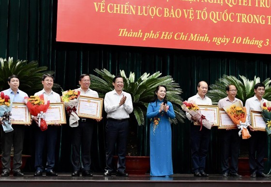 Chairman of the HCMC People's Committee Phan Van Mai (4th, L) and Chairwoman of the Vietnam Fatherland Front in HCMC Tran Kim Yen (4th, R) present certificates of merit to outstanding collectives and individuals. (Photo: SGGP)
