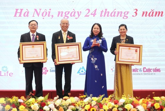 Vice State President Vo Thi Anh Xuan (2nd, R) presents Labor Order to a collective and two individuals. (Photo: SGGP)