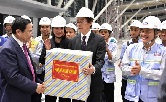 Prime Minister Pham Minh Chinh offers gifts to officers and workers of the project. (Photo: SGGP)